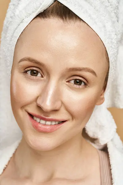 A stunning woman with natural beauty gracefully poses with a towel wrapped around her head. — Stock Photo