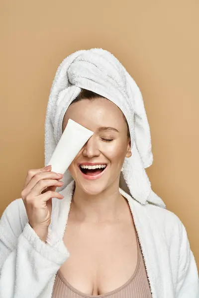 A woman exudes natural beauty with a towel wrapped around her head, showcasing elegance and grace. — Stock Photo