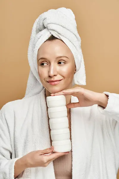 A natural beauty in a white robe, holding cream with grace and elegance. — Stock Photo