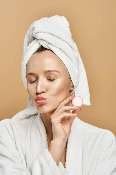Uma mulher com uma toalha enrolado em torno de sua cabeça fica graciosamente, incorporando beleza natural e atenção plena. — Fotografia de Stock