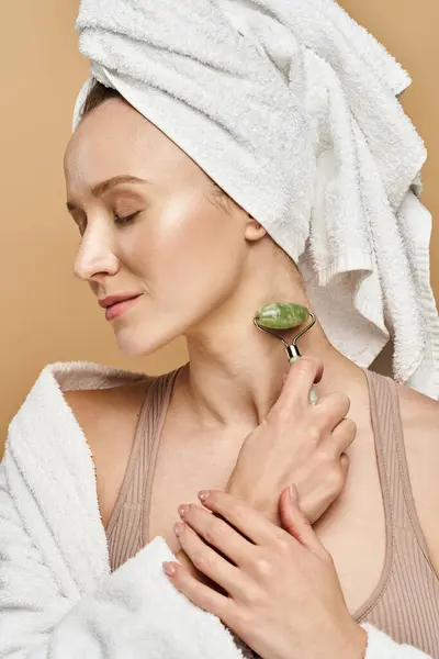 Una mujer reclinada con una toalla delicadamente envuelta alrededor de su cabeza, mostrando belleza natural y gracia. - foto de stock
