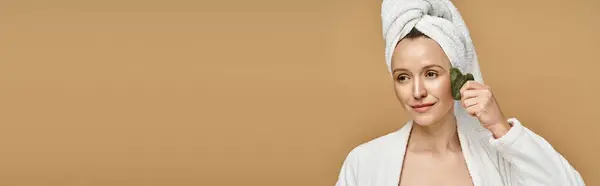A natural beauty, an attractive woman poses gracefully with a towel wrapped around her head. — Stock Photo