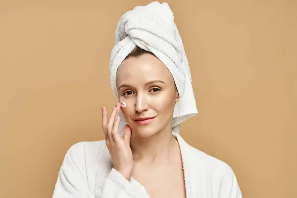 An attractive woman with natural beauty, elegantly posing with a towel wrapped around her head. — Stock Photo
