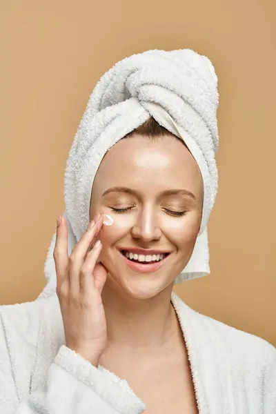 A beautiful woman with a towel wrapped around her head smiles warmly and exudes natural beauty. — Stock Photo