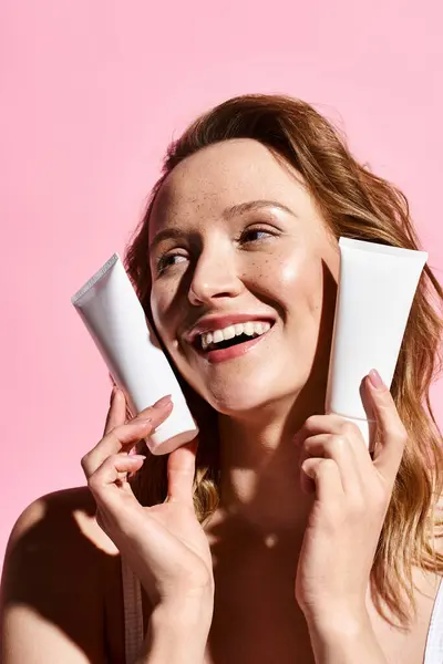 A natural beauty of a woman playfully holding cream in front of her face. — Stock Photo