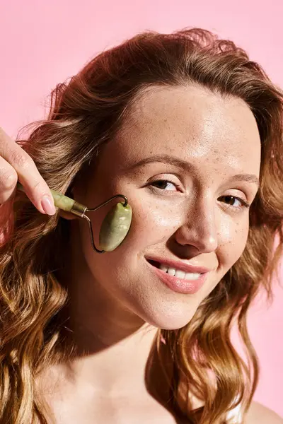 A creative woman with face roller, showcasing natural beauty and artistic flair. — Stock Photo