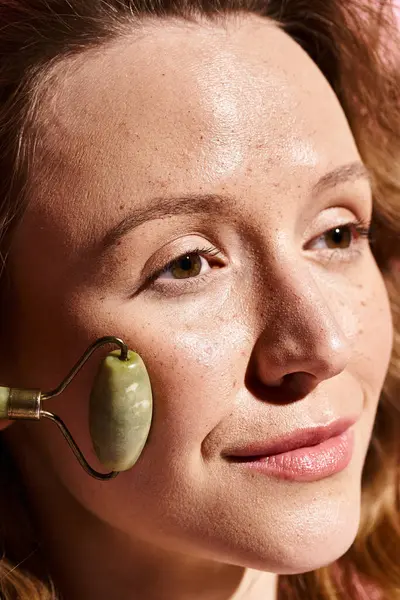 A stunning woman with natural beauty showcasing face roller with elegance and grace. — Stock Photo
