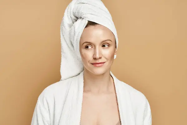 Una bella donna con un asciugamano avvolto intorno alla testa, trasudando bellezza naturale e serenità. — Foto stock