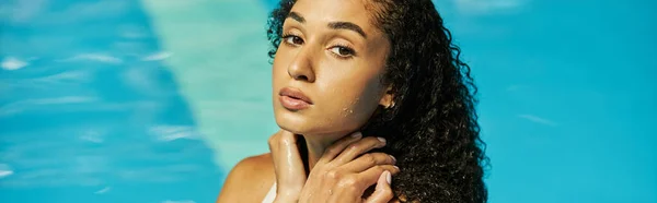Junge schwarze Frau mit nassen lockigen Haaren, die kühles blaues Poolwasser steht und in die Kamera schaut, Banner — Stockfoto
