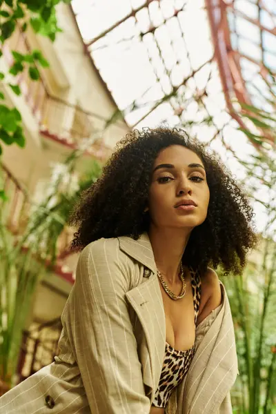 Young african american woman in botanical garden, blending high fashion with wild nature — Stock Photo