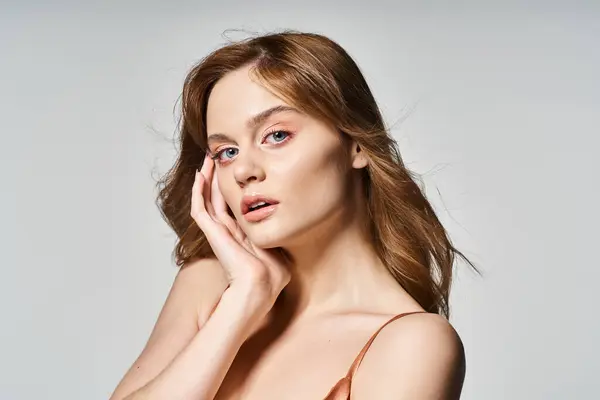 Beauty portrait of beautiful woman with natural makeup, looking at camera with hands near her face — Stock Photo