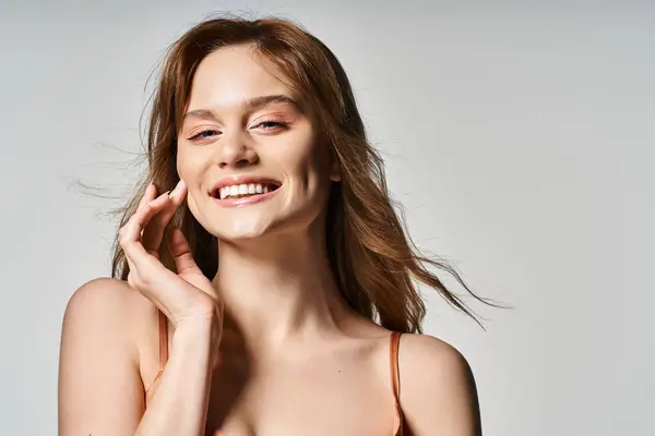 Schönheitsporträt einer lächelnden Frau mit trendigem Make-up, die in die Kamera auf grauem Studiohintergrund blickt — Stockfoto