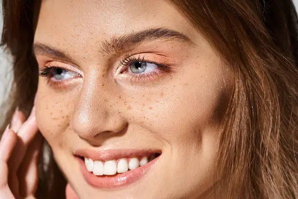Nahaufnahme Schönheit Porträt der lächelnden Frau mit Pfirsich Make-up und Sommersprossen auf grauem Hintergrund — Stockfoto