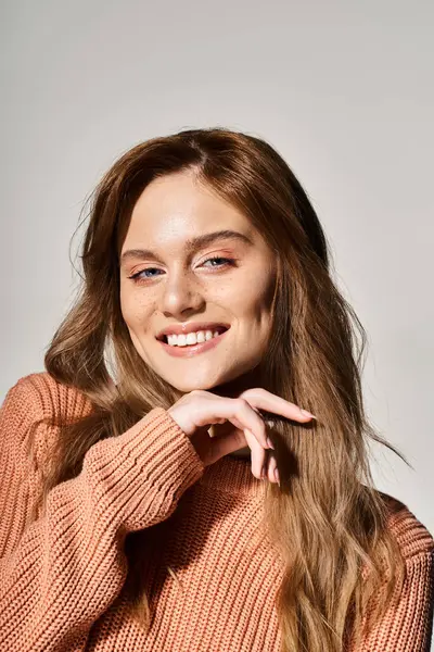 Retrato de mulher sorridente olhando para a câmera com maquiagem natural, vestindo suéter, tocando seu queixo — Fotografia de Stock