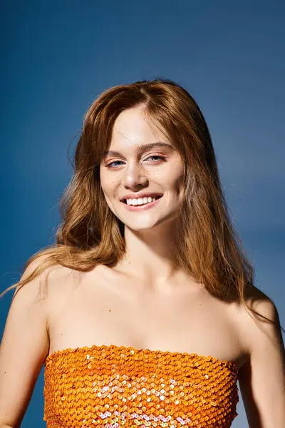Retrato de belleza de mujer sonriente con ojos azules, maquillaje de melocotón y pecas sobre fondo azul - foto de stock