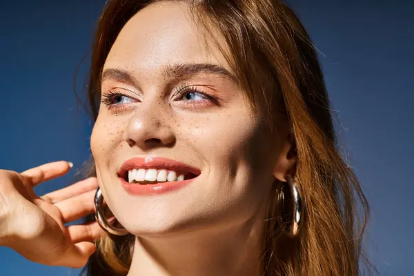 Nahaufnahme Foto von Mädchen mit Lächeln, Pfirsich natürliches Make-up mit Sommersprossen auf blauem Hintergrund — Stockfoto