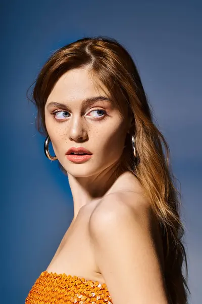 Seitenansicht eines lächelnden Mädchens mit blauen Augen, pfirsichfarbenem Make-up mit Sommersprossen auf blauem Hintergrund — Stockfoto