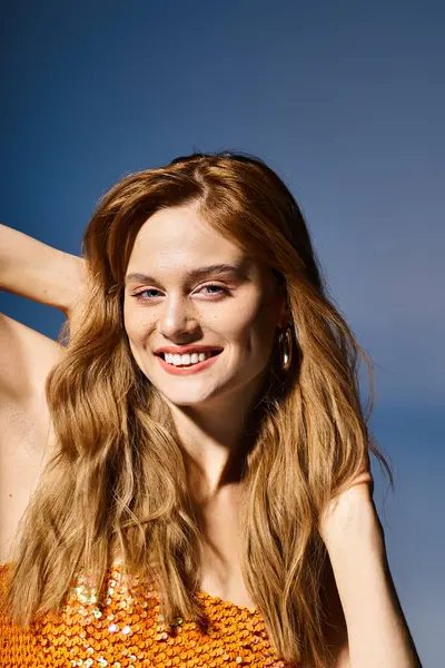 Beleza tiro de alegre jovem mulher sorrindo, tocando seu cabelo no fundo azul escuro — Fotografia de Stock