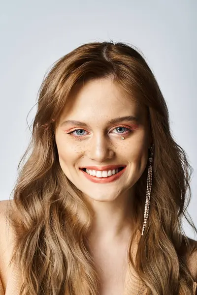 Ritratto di bellezza di giovane donna sorridente con trucco di gioielli viso su sfondo grigio — Foto stock