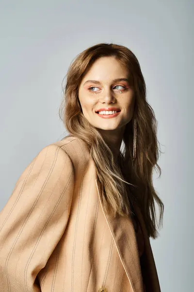 Mulher sorridente em jaqueta bege, vestindo maquiagem nua com jóias no rosto, olhando para longe — Fotografia de Stock
