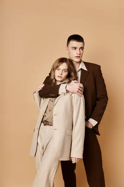 Elegant handsome man in debonair suit posing next to his beautiful girlfriend who looking at camera — Stock Photo