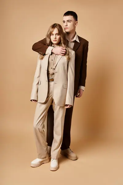 Good looking man in debonair suit posing next to his beautiful girlfriend who looking at camera — Stock Photo