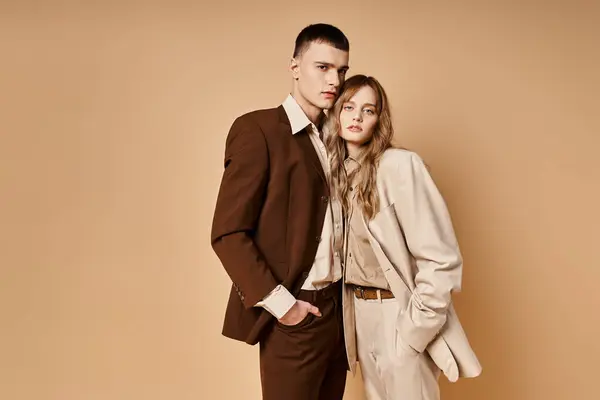 Attraktive junge Frau im eleganten Anzug posiert mit ihrem hübschen Freund und schaut in die Kamera — Stockfoto