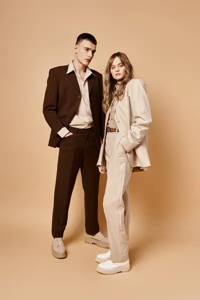 Elegante junge Frau im eleganten Anzug posiert mit ihrem hübschen Freund und schaut in die Kamera — Stockfoto
