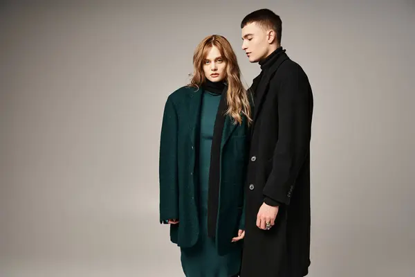 Good looking man in coat posing lovingly next to his beautiful girlfriend who looking at camera — Stock Photo