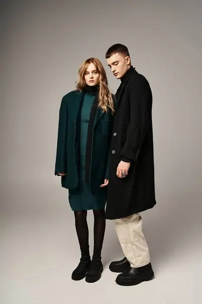 Good looking man in coat posing lovingly next to his beautiful girlfriend who looking at camera — Stock Photo