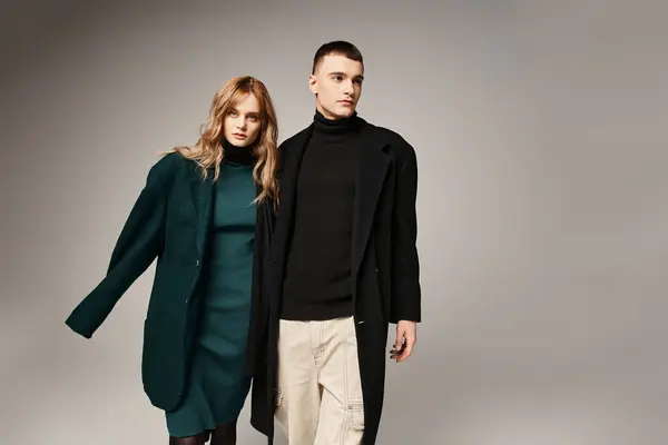 Handsome man in coat posing lovingly next to his beautiful girlfriend who looking at camera — Stock Photo