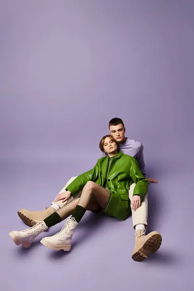 Mulher atraente em casaco verde elegante olhando para a câmera sentada ao lado de seu namorado bonito — Fotografia de Stock