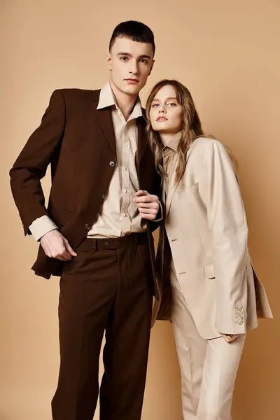 Atractiva pareja de moda en trajes elegantes posando sobre fondo pastel y mirando a la cámara - foto de stock