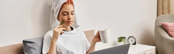 Schöne queere Person mit Haartuch und Gesichtsroller, die Tee trinkt, während sie Filme anschaut, Banner — Stockfoto