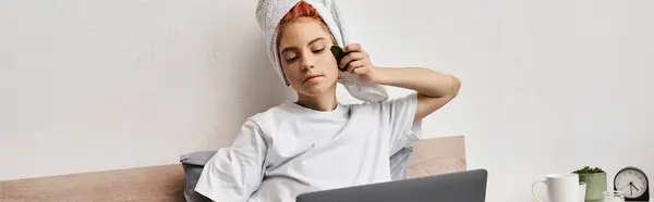 Alegre muito queer pessoa com toalha de cabelo assistindo filmes no laptop e usando gua sha na cama, banner — Fotografia de Stock