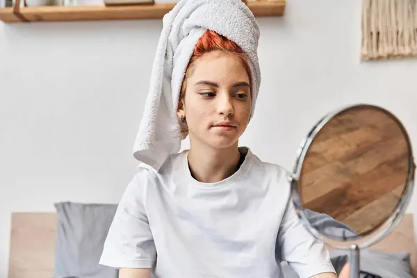 Attraente persona stravagante con asciugamano bianco guardando allo specchio durante la routine mattutina a casa — Foto stock