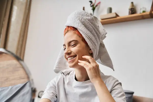 Allegra persona stravagante con asciugamano bianco guardando allo specchio durante la routine mattutina a casa — Foto stock