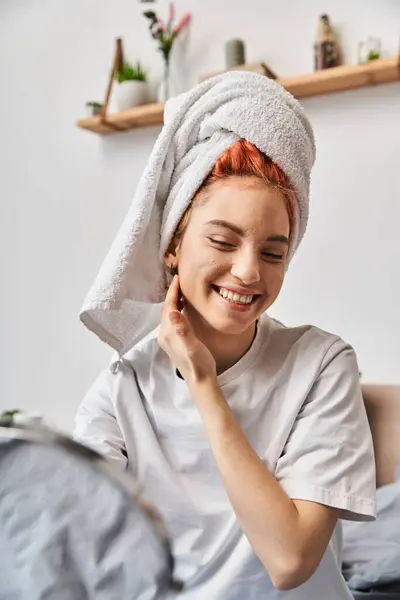 Alegre pessoa extravagante com toalha de cabelo branco olhando no espelho durante a rotina da manhã em casa — Fotografia de Stock