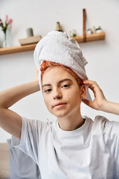 Beautiful positive queer person in homewear with hair towel looking at camera, morning routine — Stock Photo
