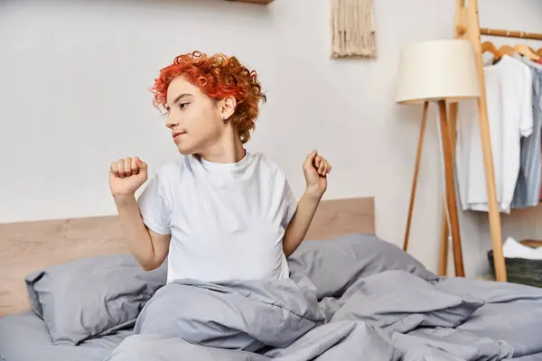 Extravagante bela pessoa queer em traje casual acordar e esticar na cama, tempo de lazer — Fotografia de Stock