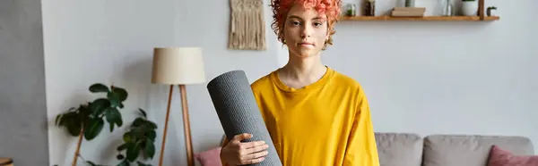 Sportif queer personne aux cheveux roux en tenue vibrante tenant tapis de yoga et regardant caméra, bannière — Photo de stock