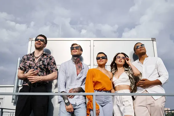 Joyful young multicultural friends in vivid casual attires posing on rooftop and looking away — Stock Photo