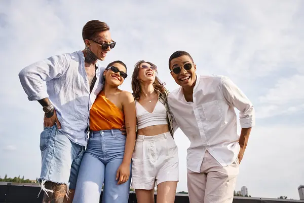 Jolly diverse good looking friends with stylish sunglasses posing joyfully on rooftop together — Stock Photo