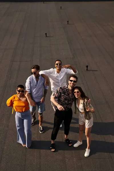 Cinq amis gais multiraciaux en vêtements vibrants posant sur le toit et souriant joyeusement à la caméra — Photo de stock