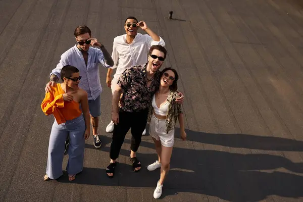 Cinq amis gais interracial en vêtements vibrants posant sur le toit et souriant joyeusement à la caméra — Photo de stock