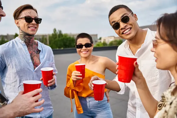 Cheerful interracial friends with stylish sunglasses spending time together at rooftop party — Stock Photo
