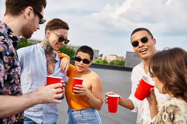 Fröhliche multirassische Freunde mit trendigen Sonnenbrillen, die auf der Dachterrassenparty eine tolle Zeit miteinander verbringen — Stockfoto