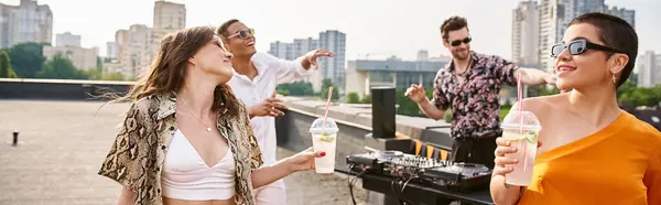 Allegri amici diversi con occhiali da sole che bevono alla festa sul tetto e ballano sul dj set, banner — Foto stock