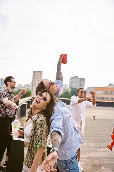 Amigos inter-raciais felizes com óculos de sol bebendo coquetéis na festa no telhado e refrigeração para DJ set — Fotografia de Stock