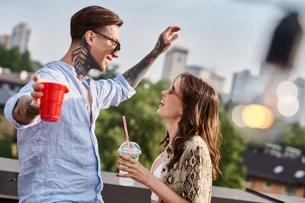 Ansprechende, gut gelaunte Freunde mit stylischer Sonnenbrille, die Spaß bei einer Dachparty mit Cocktails haben — Stockfoto